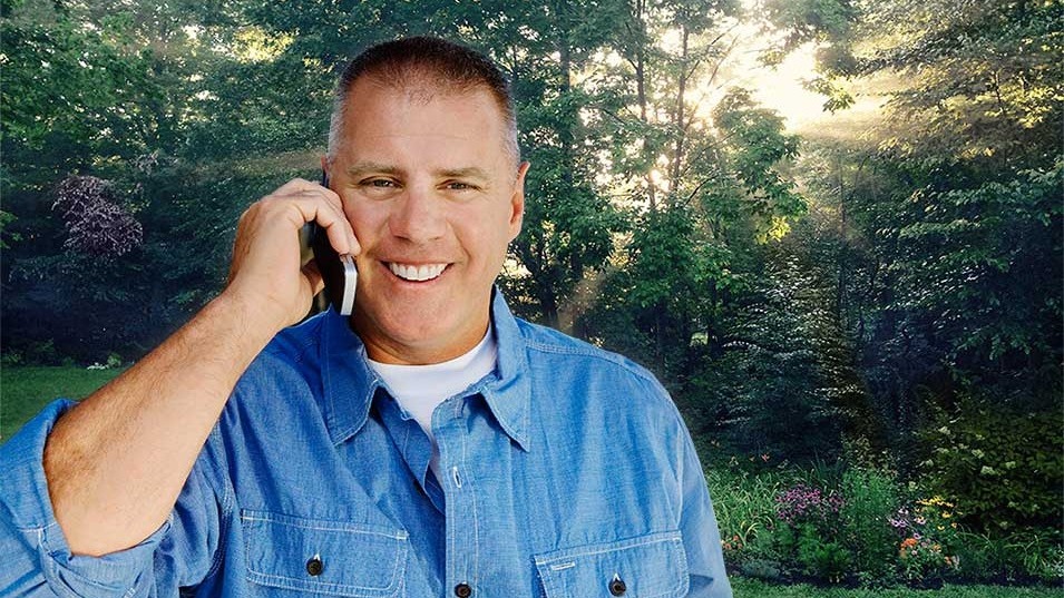 landscaping contractor on mobile phone at jobsite.