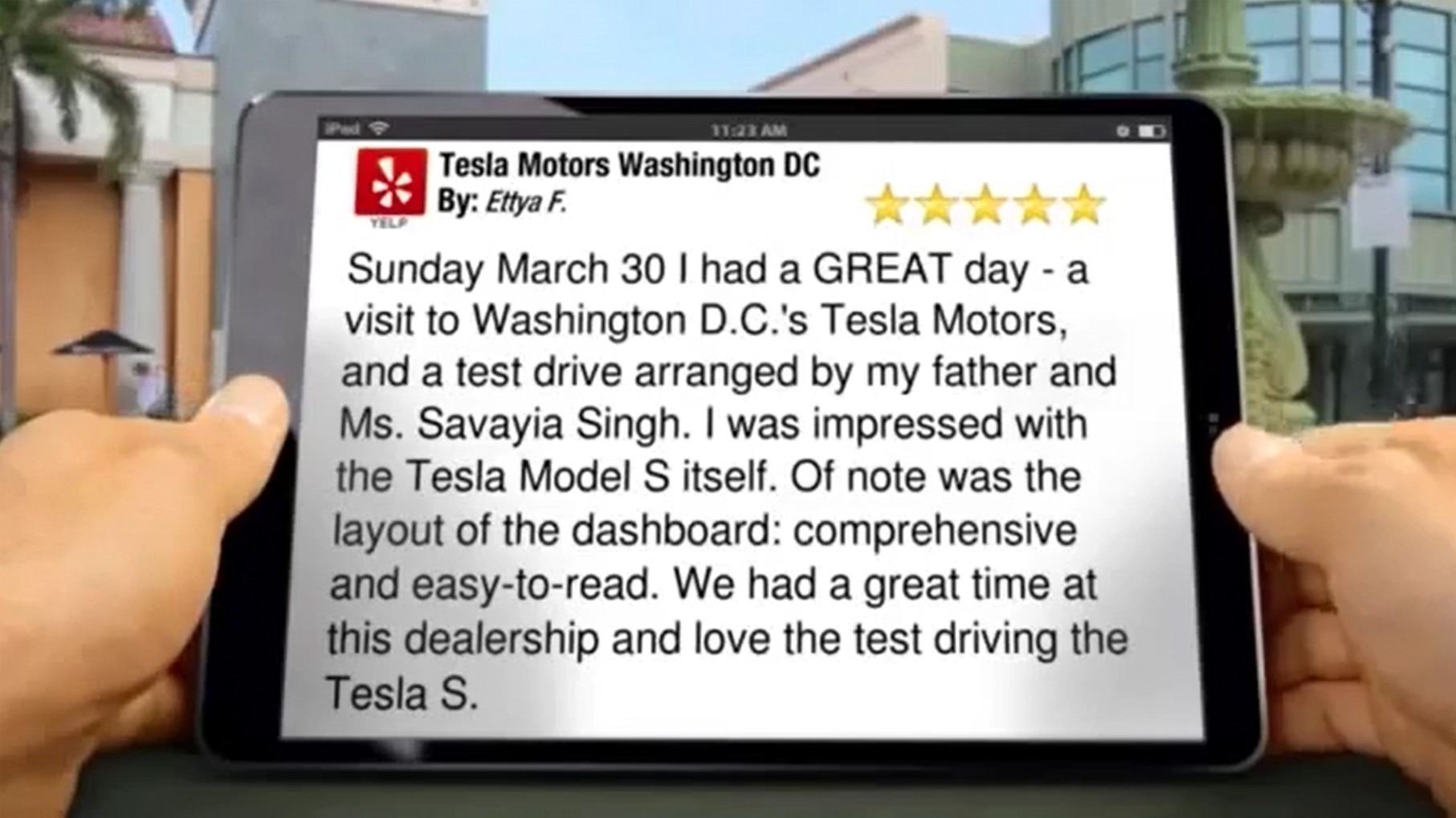Fellow holding iPad with Tesla 5 Star Review
