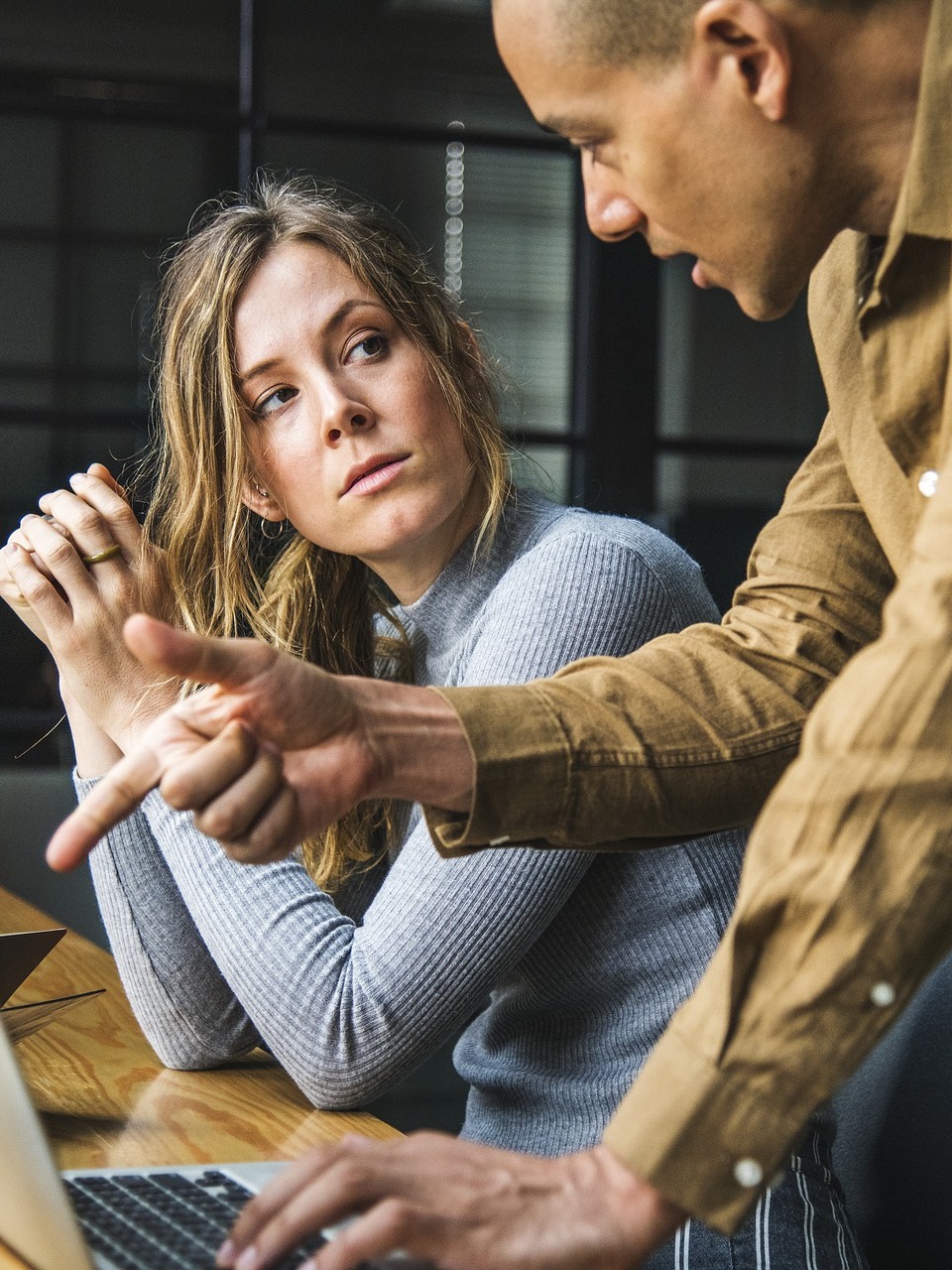 man and women at computer discussing business