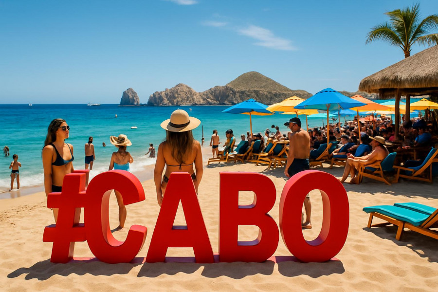 Cabo San Lucas beach with iconic sign and lively atmosphere.