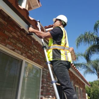 Man on a ladder checking for lead