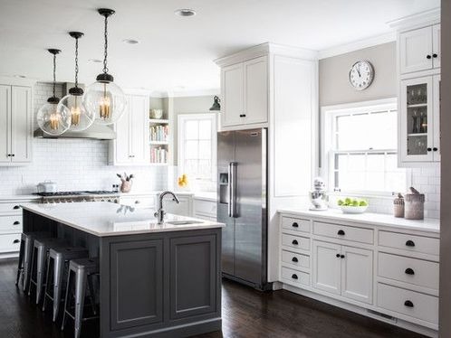 modern kitchen with island and white cabinets and dark wood floor