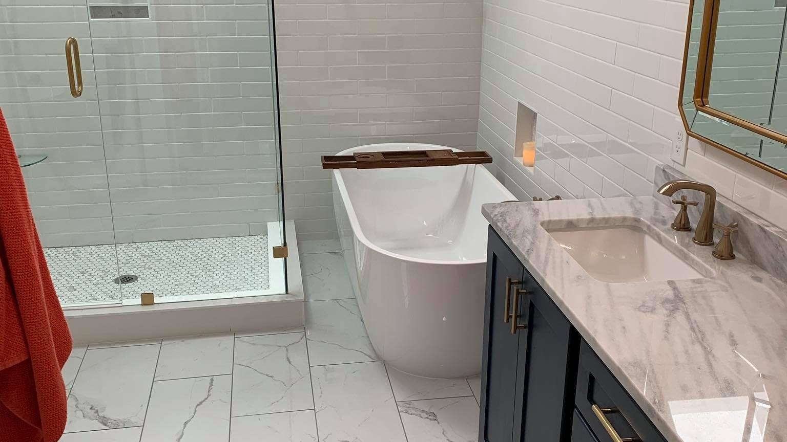 bathroom renovations with tub and glass shower and brown vanity cabinets with mirror