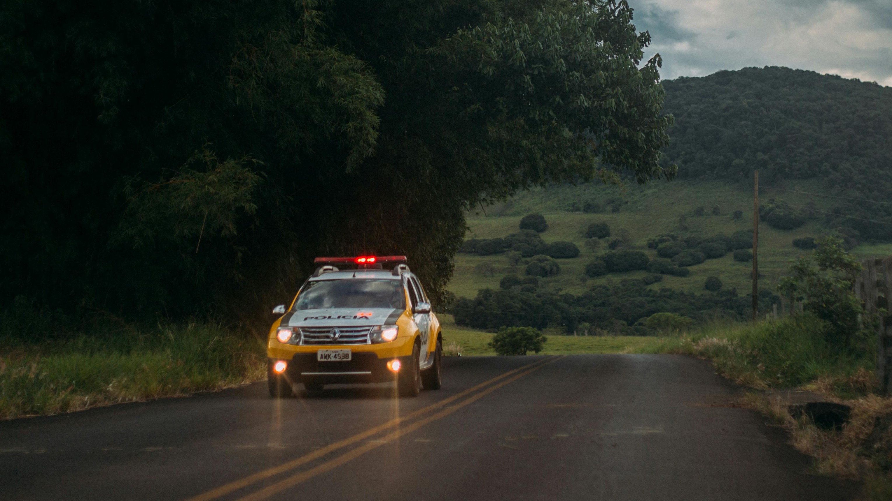 Investigators in forest near Devil's Den, gathering evidence in sunlight.
