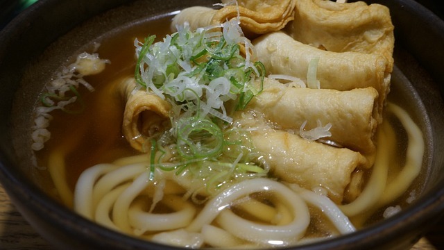 Chef presenting authentic Asian cuisine in a traditional kitchen setting.