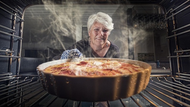 Middle-aged woman smiling while cooking in a kitchen, Baking Together