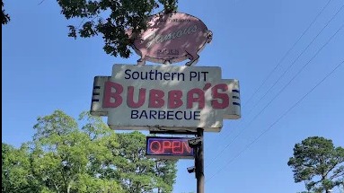 Bubba's Barbecue Eureka Springs sign against blue sky.