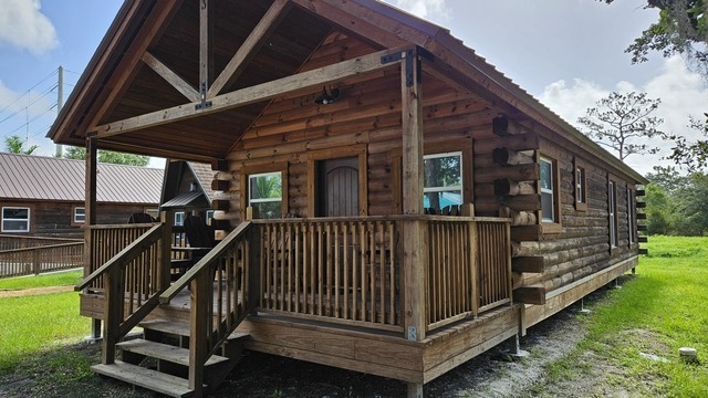 Modern church camp cabins at Camp Impact, comfortable and inviting lodging for groups, surrounded by Central Florida palm trees, guests arriving with bags, best church camp accommodations in Central Florida