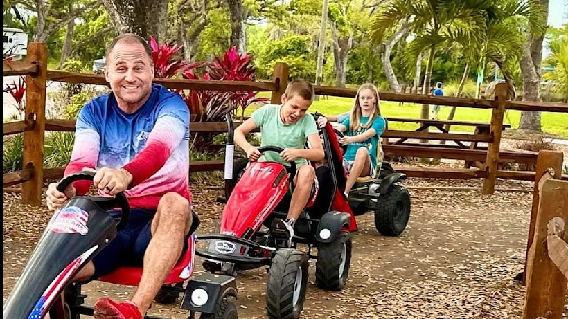 Welcoming church camp staff member greeting large ministry group arriving at Camp Impact, Central Florida, modern entrance and inviting landscape at church camp in Central Florida