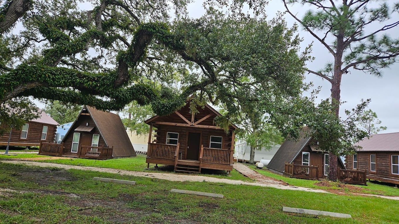 Modern, cozy cabins at Camp Impact, families and youth groups unpacking, surrounded by greenery and picnic tables—church camp in florida accommodations for all church and ministry groups.