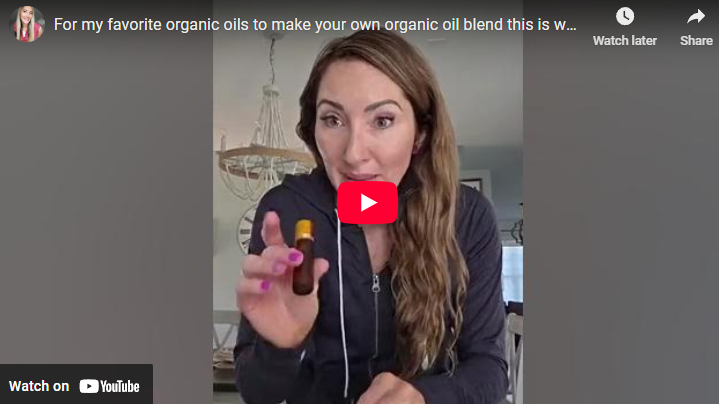 Woman demonstrating organic oil blends in cozy setting.