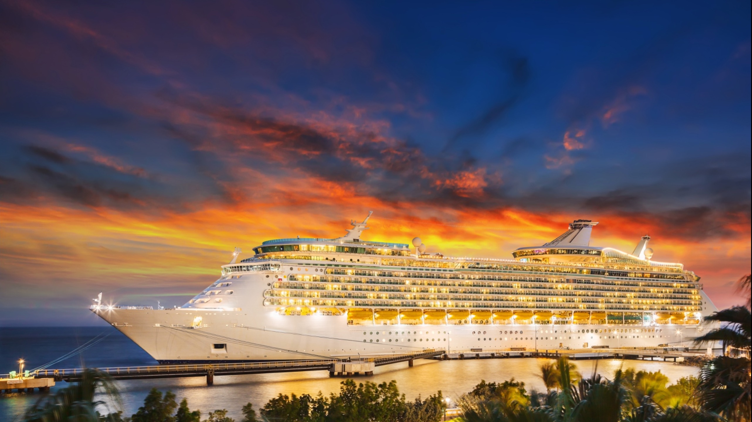 Luxury Cruise Ship Pulling into Port at Sunset by The Travel Agent