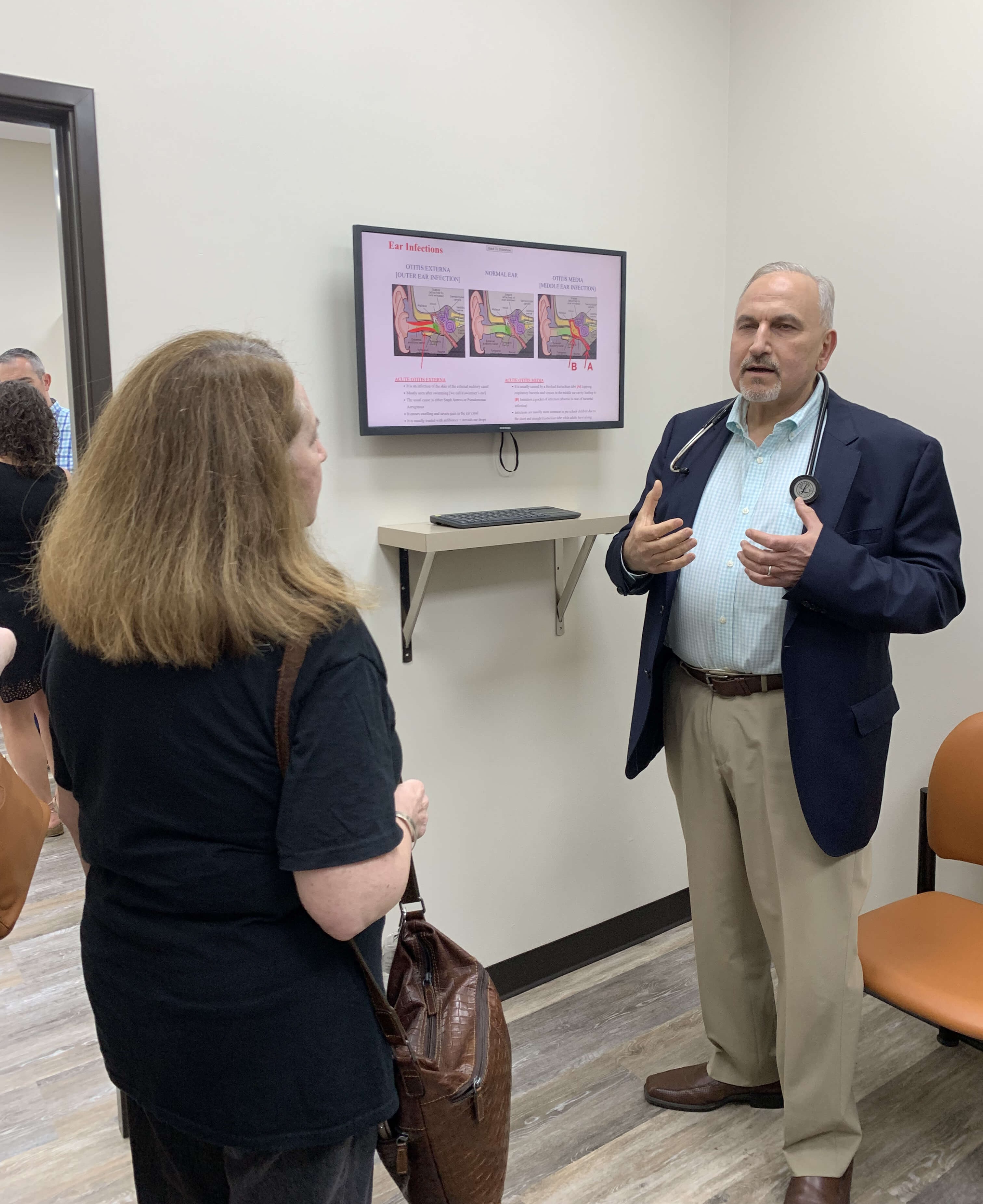 Dr. Nasry showing the Education Panel at Medical Care 1 Urgent Care Farmington