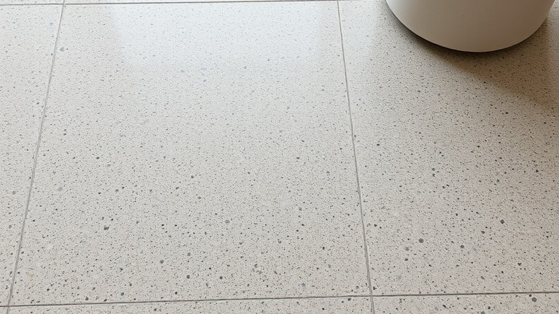 Wombat flake epoxy textured floor in light gray and beige tones.