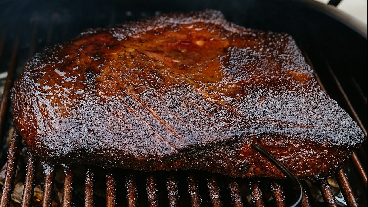 Close-up of smoked brisket flat in a smoker, highlighting BBQ techniques and brisket cooking methods.