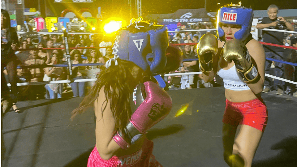 Young girl and coach bonding while gaining confidence through boxing in gym.
