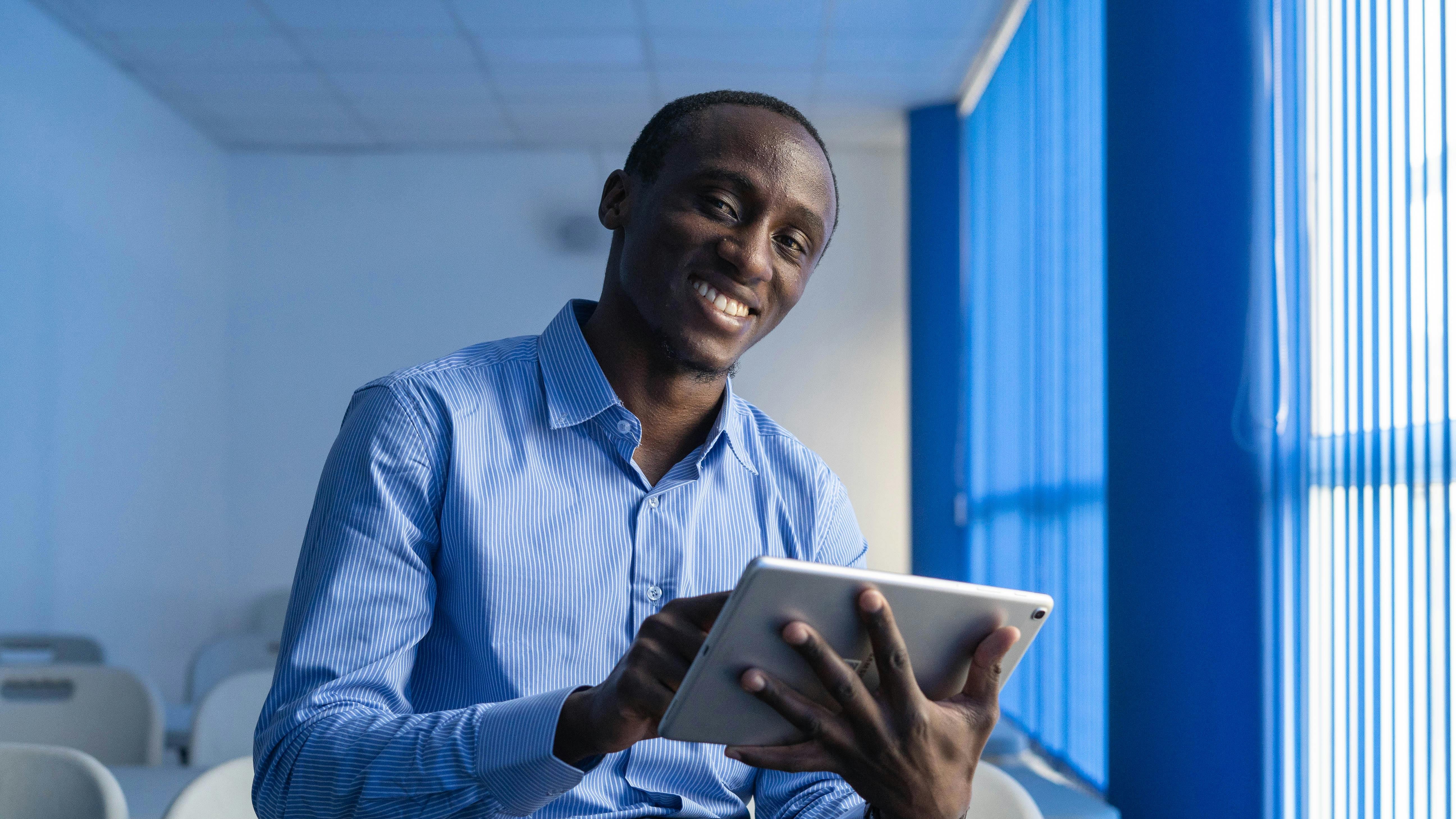 Professional portrait of a smiling man in a blue suit, representing digital payments in Nigeria.