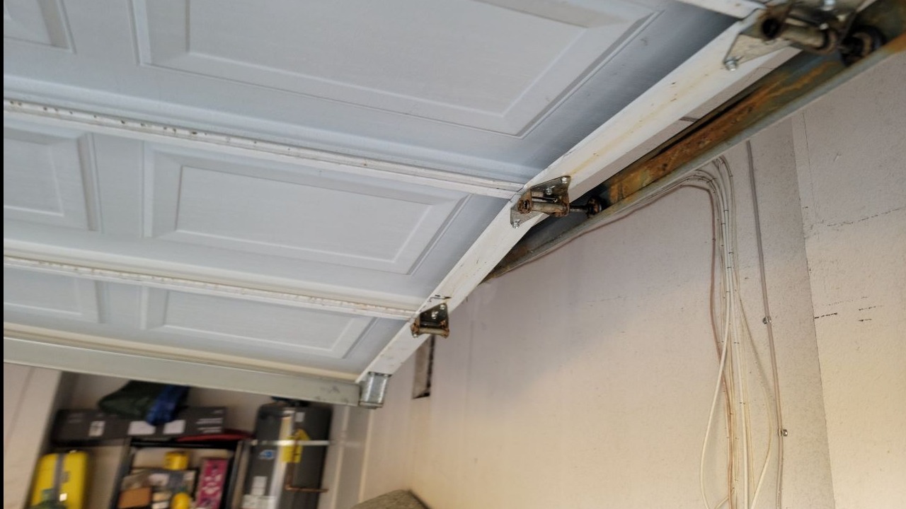 Closeup of a damaged garage door roller showing rust—highlighting need for garage door opener repair.