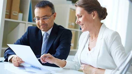 Man and woman viewing tax form are pleased with their tax preparation and other tax services received.
