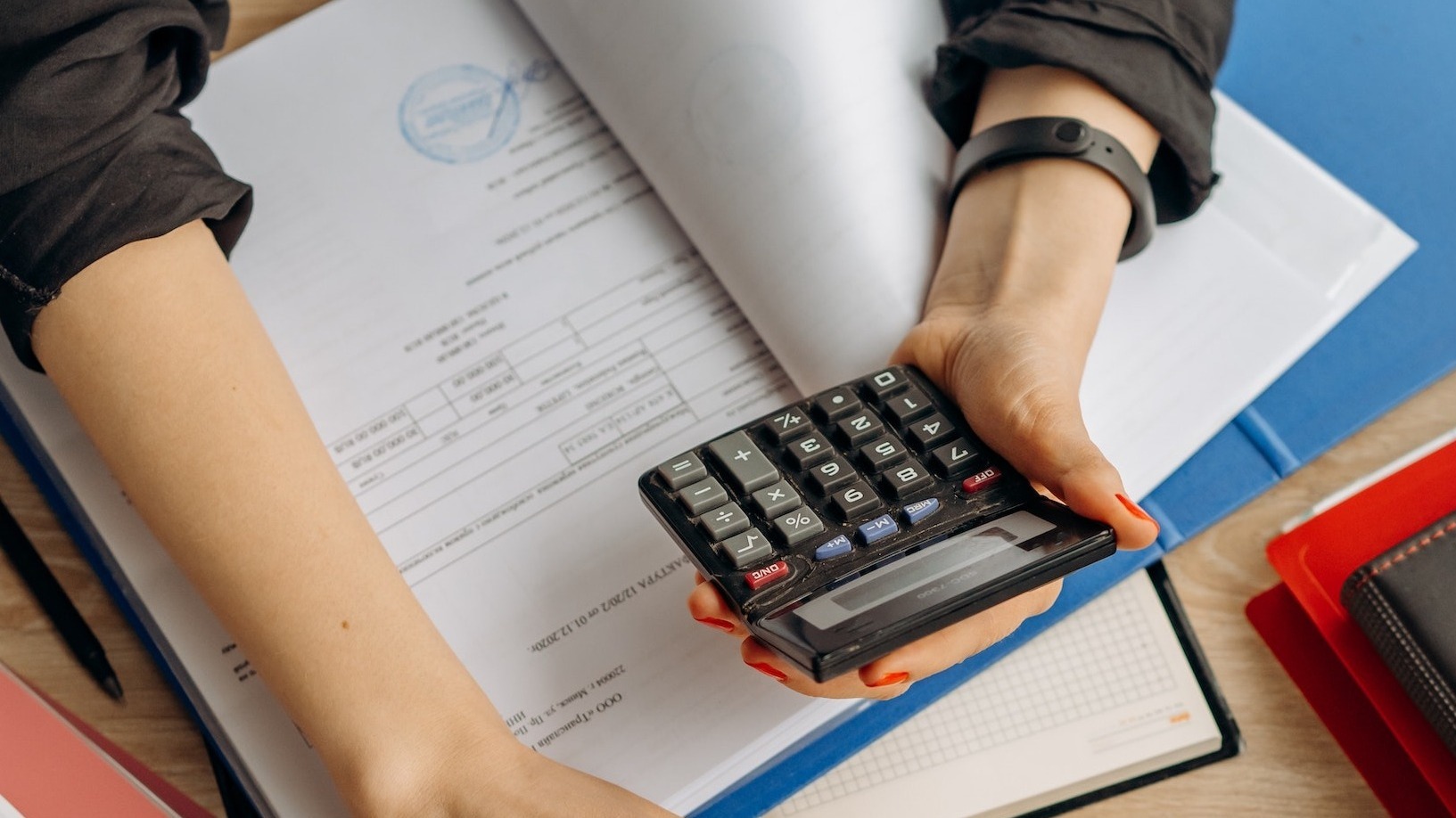 close-up of Cheryl Moir holding calculator for tax preparation
