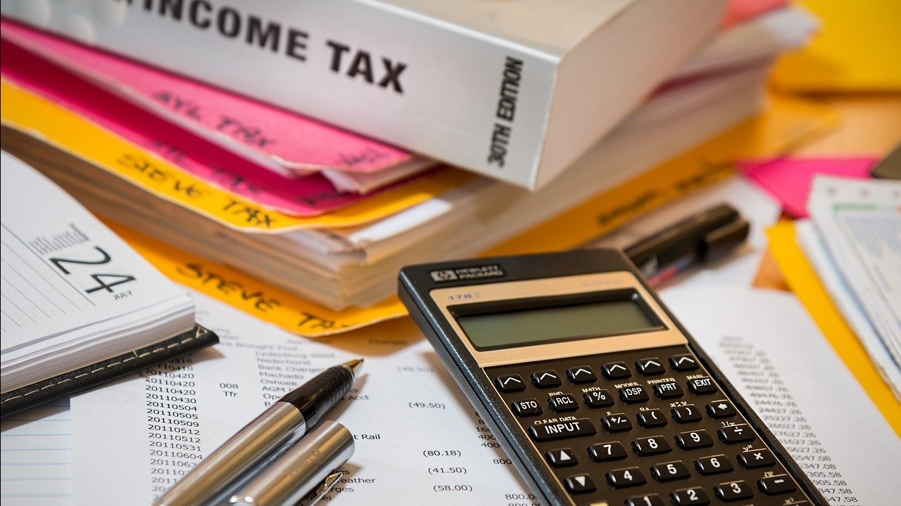 Income tax book, calculator, and other images to represent tax preparation