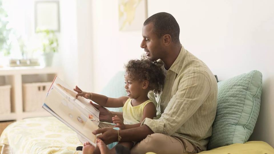 Father reading to daughter
