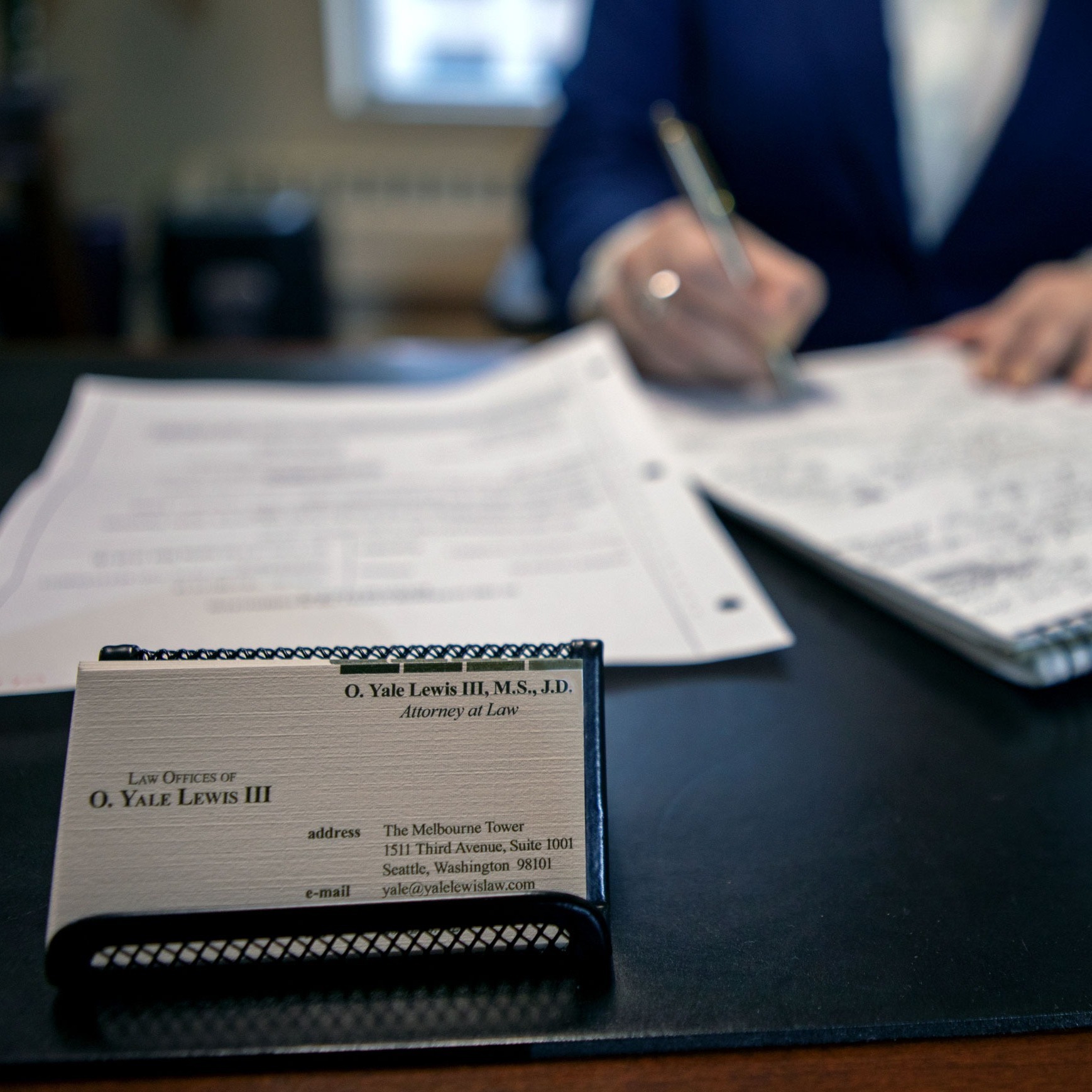 Desk of Yale Lewis with focus on business cards