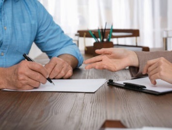 Hands signing documents