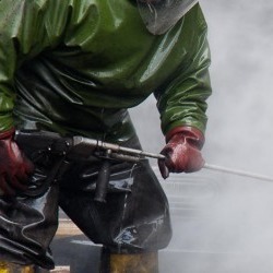 Man pressure cleaning in green suit