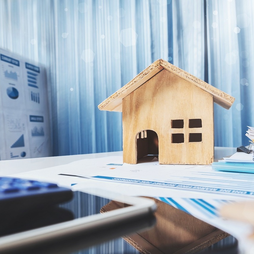 Small wooden house next to estate planning documents