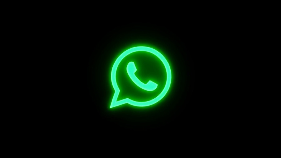 Luminous green neon WhatsApp logo on dark background.