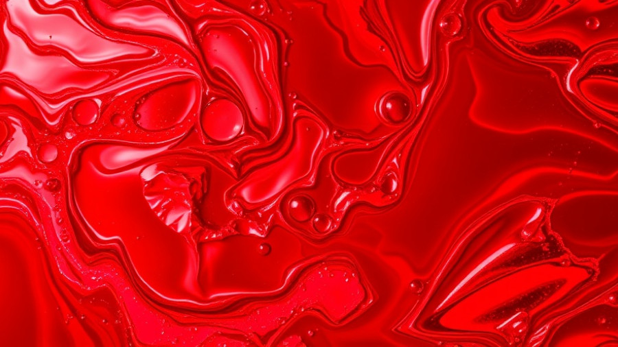 Vibrant red swirling liquid, abstract and dynamic energy.