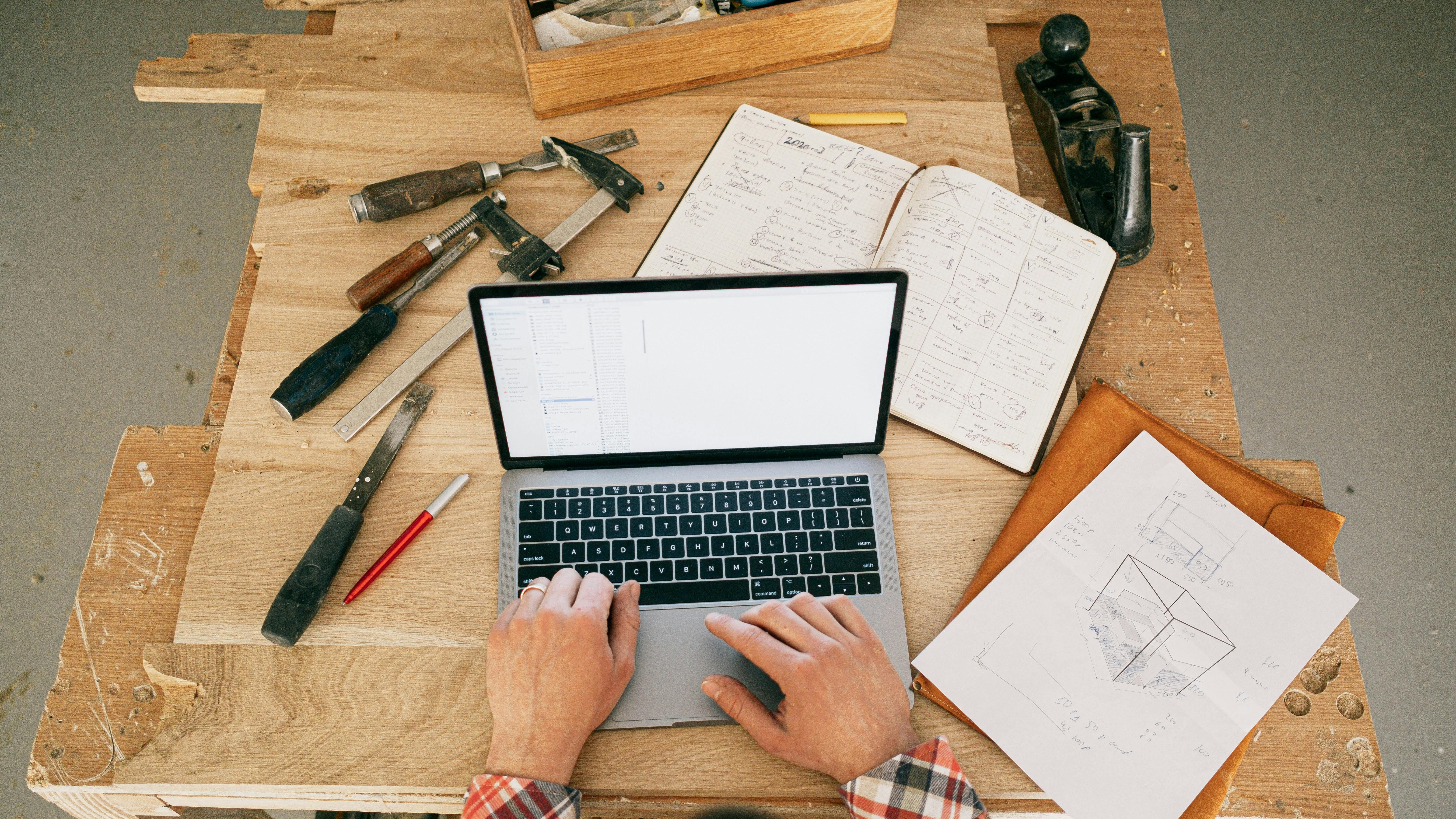 Individual engaging in work at a modern, inclusive home office with a laptop.