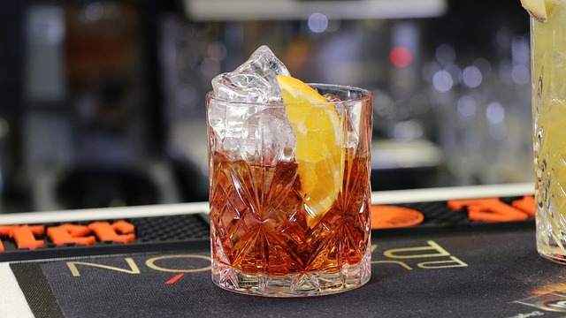 Elegant cocktail on a wooden bar, San Antonio nightlife 2025 atmosphere.