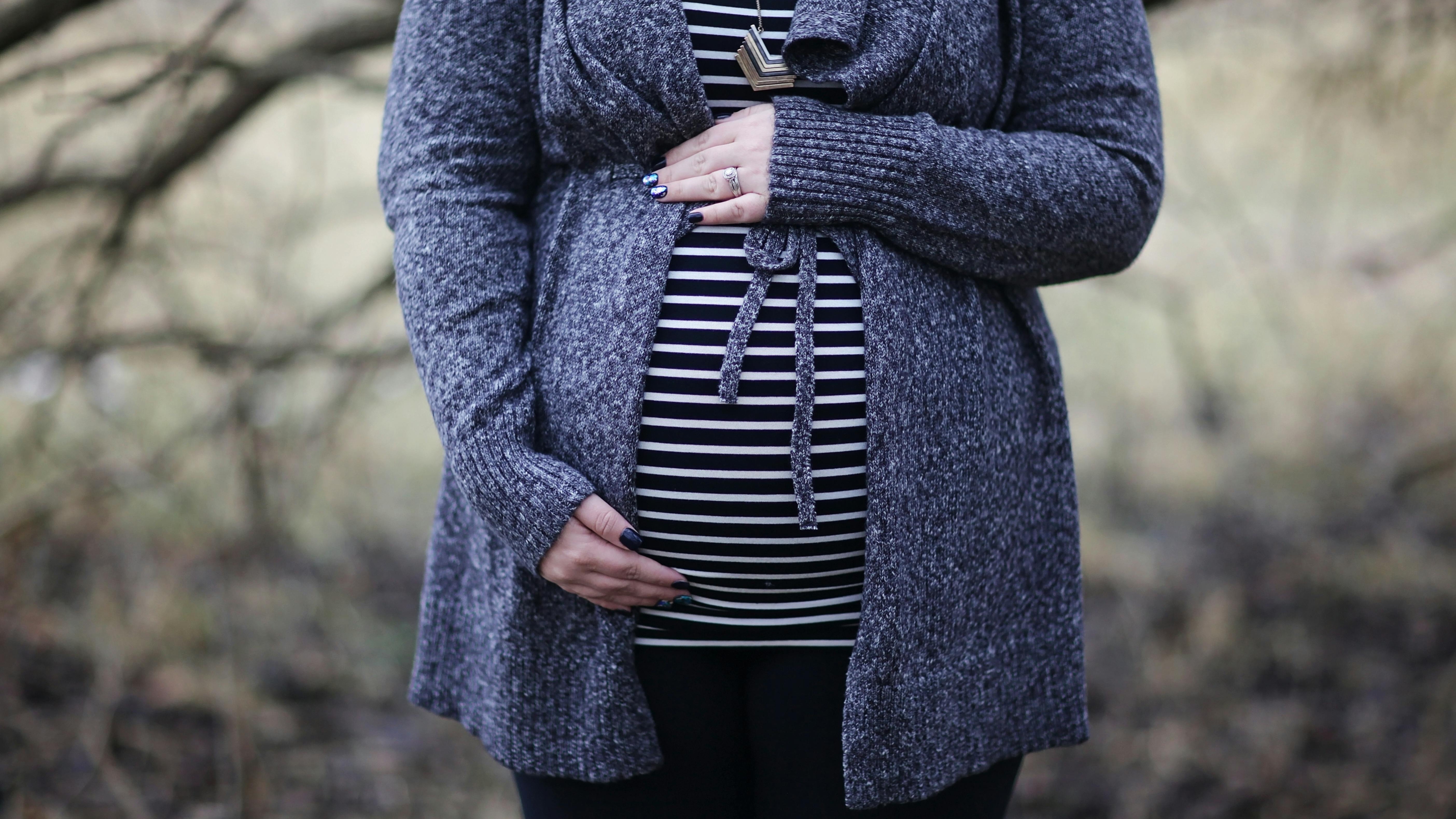 Pregnant woman with a belly, showcasing a pelvic model, illustrating SPD in pregnancy.
