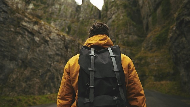 Man smiling while hiking in nature, enjoying work-life balance.