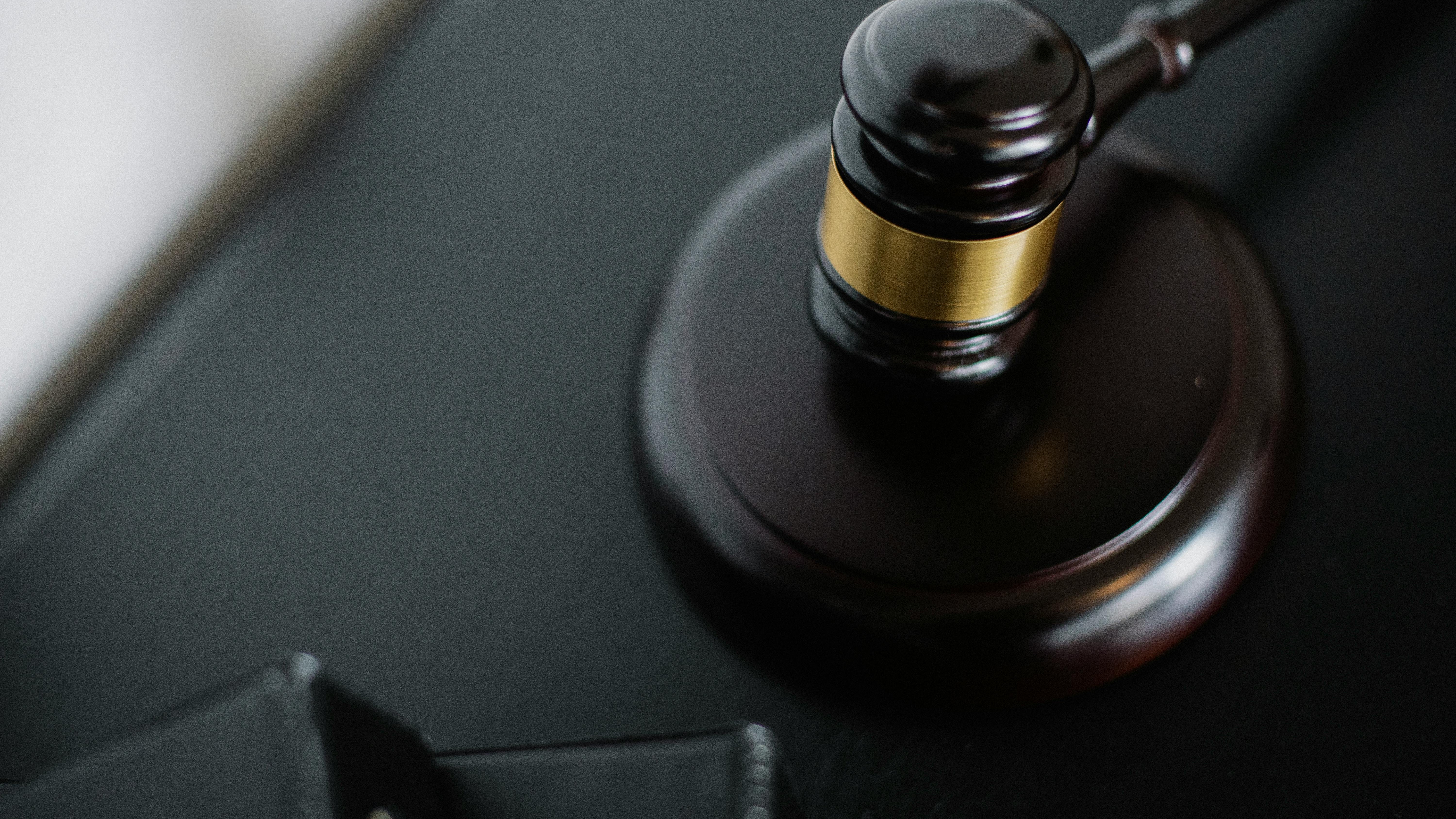 ADA compliance in workplace bias cases: gavel, law book, and 'Disability Discrimination' notebook on wooden desk.