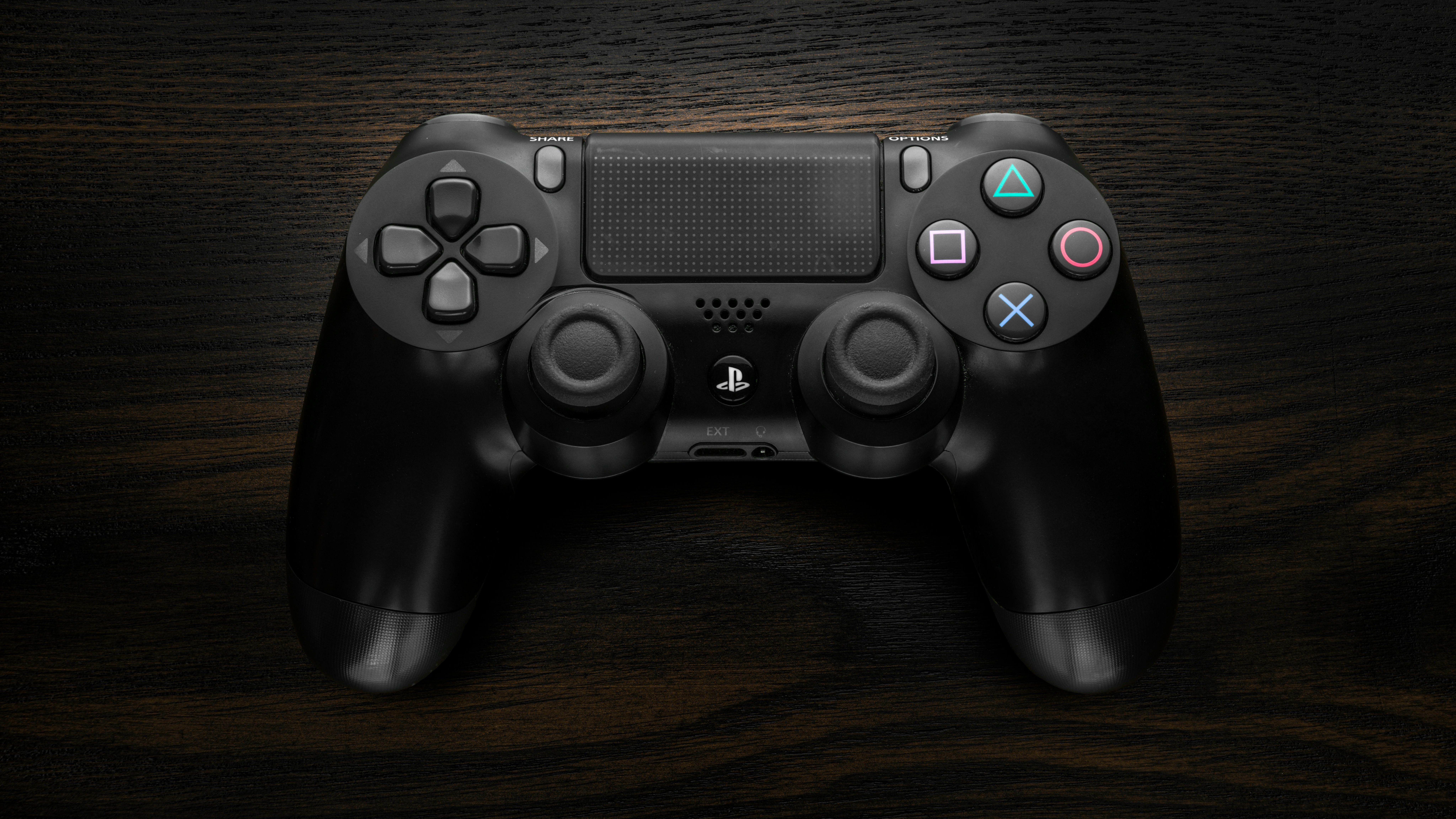 Glasses-free 3D gaming device with controller on wooden desk.