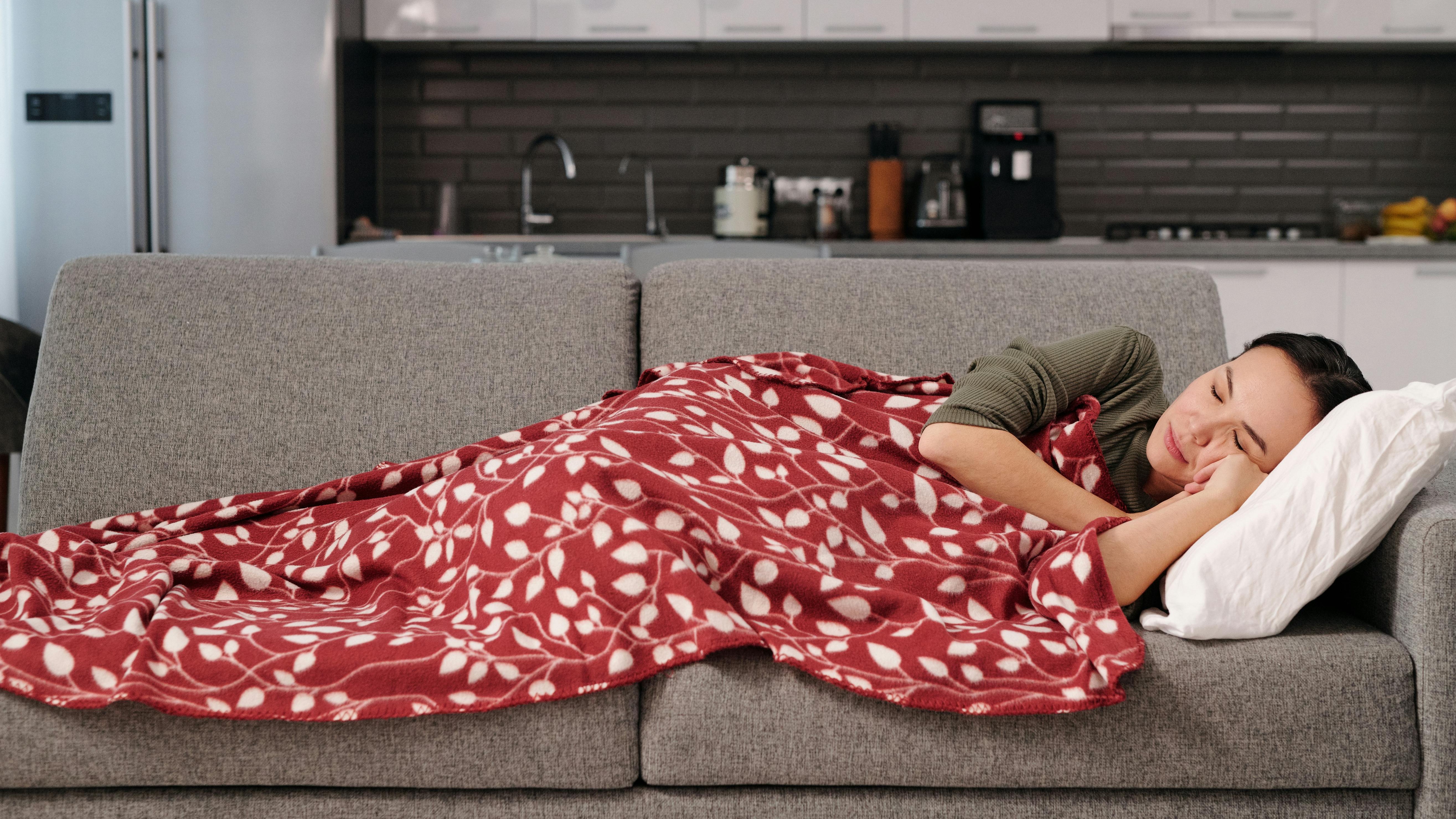 Two women in a backyard, one with a coral throw blanket.