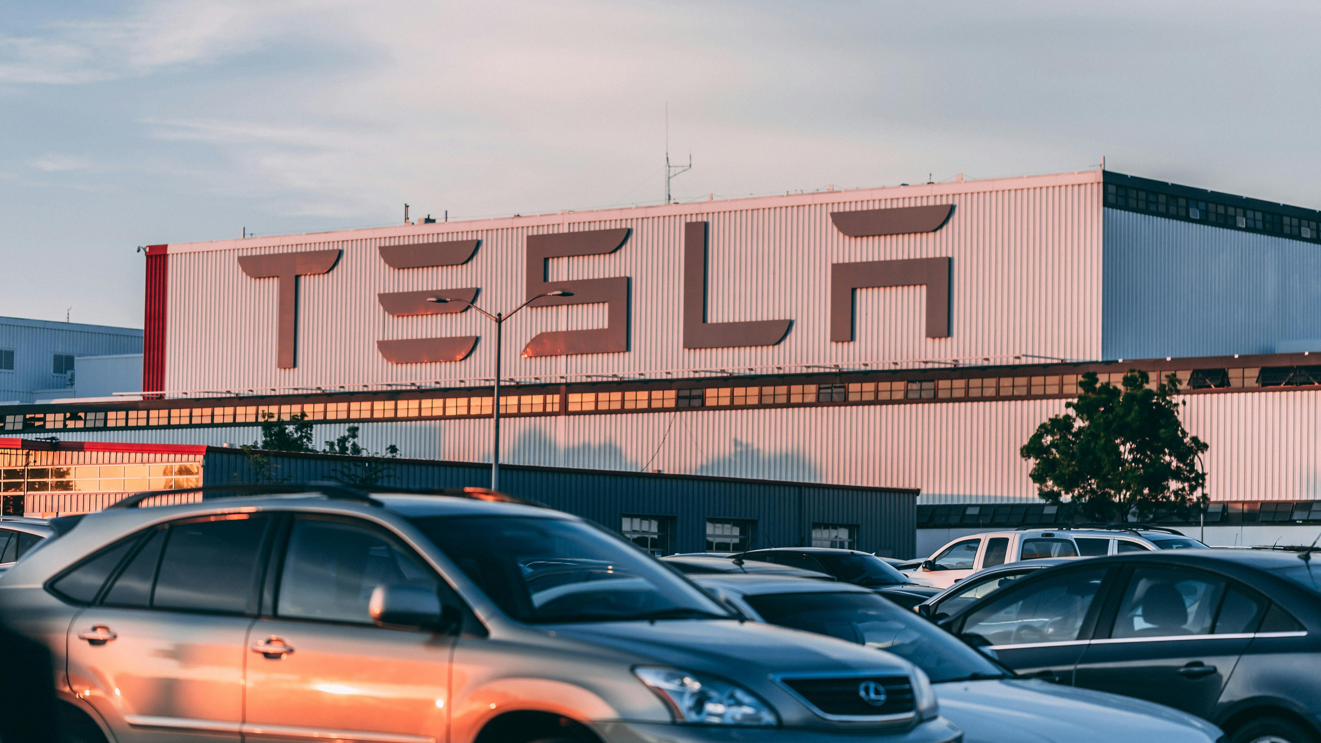 Aerial view of Tesla parking lot and factory showcasing employee engagement.