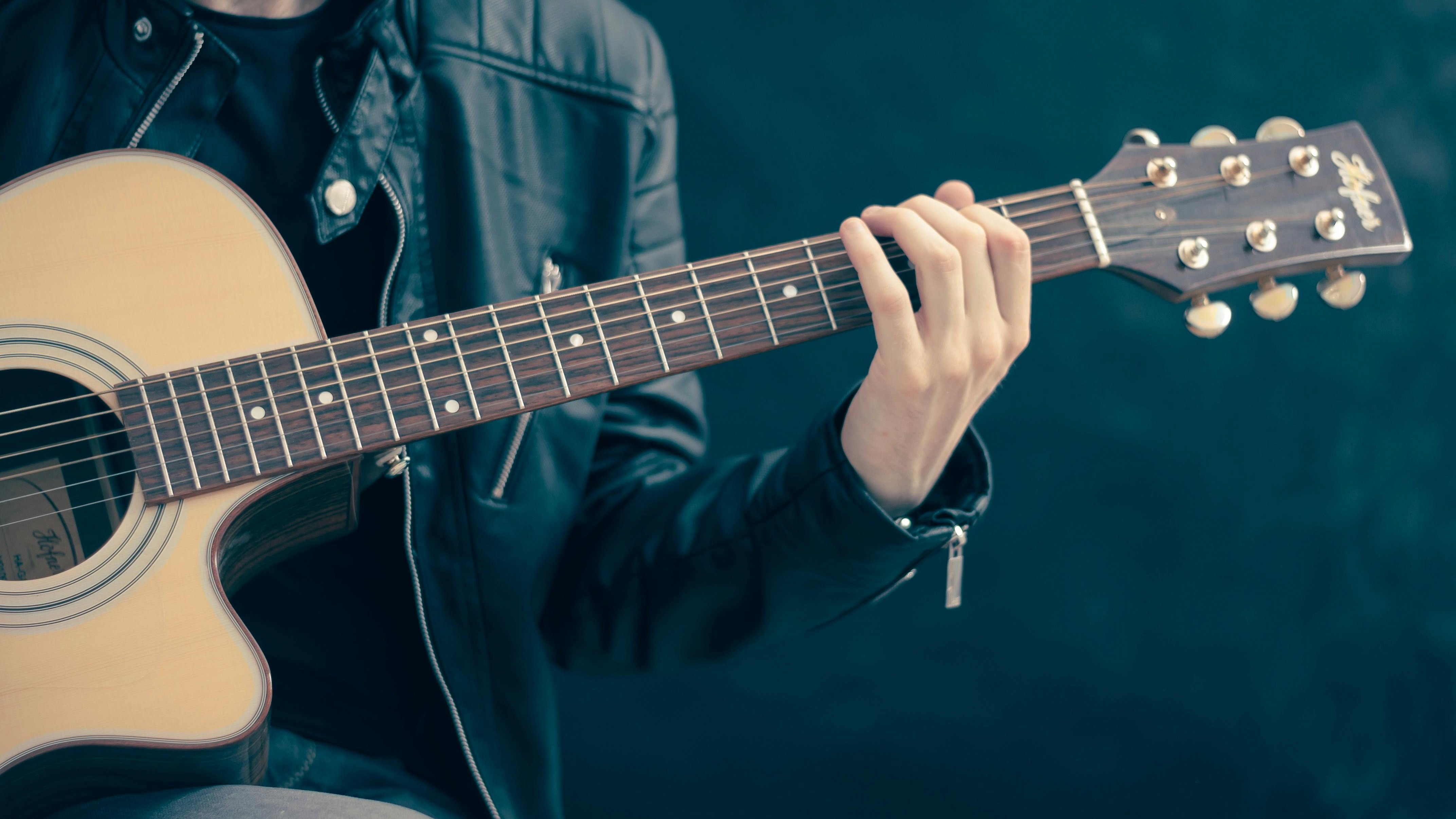 Energetic musician performing at MAHA Festival 2025 with red stage lighting.