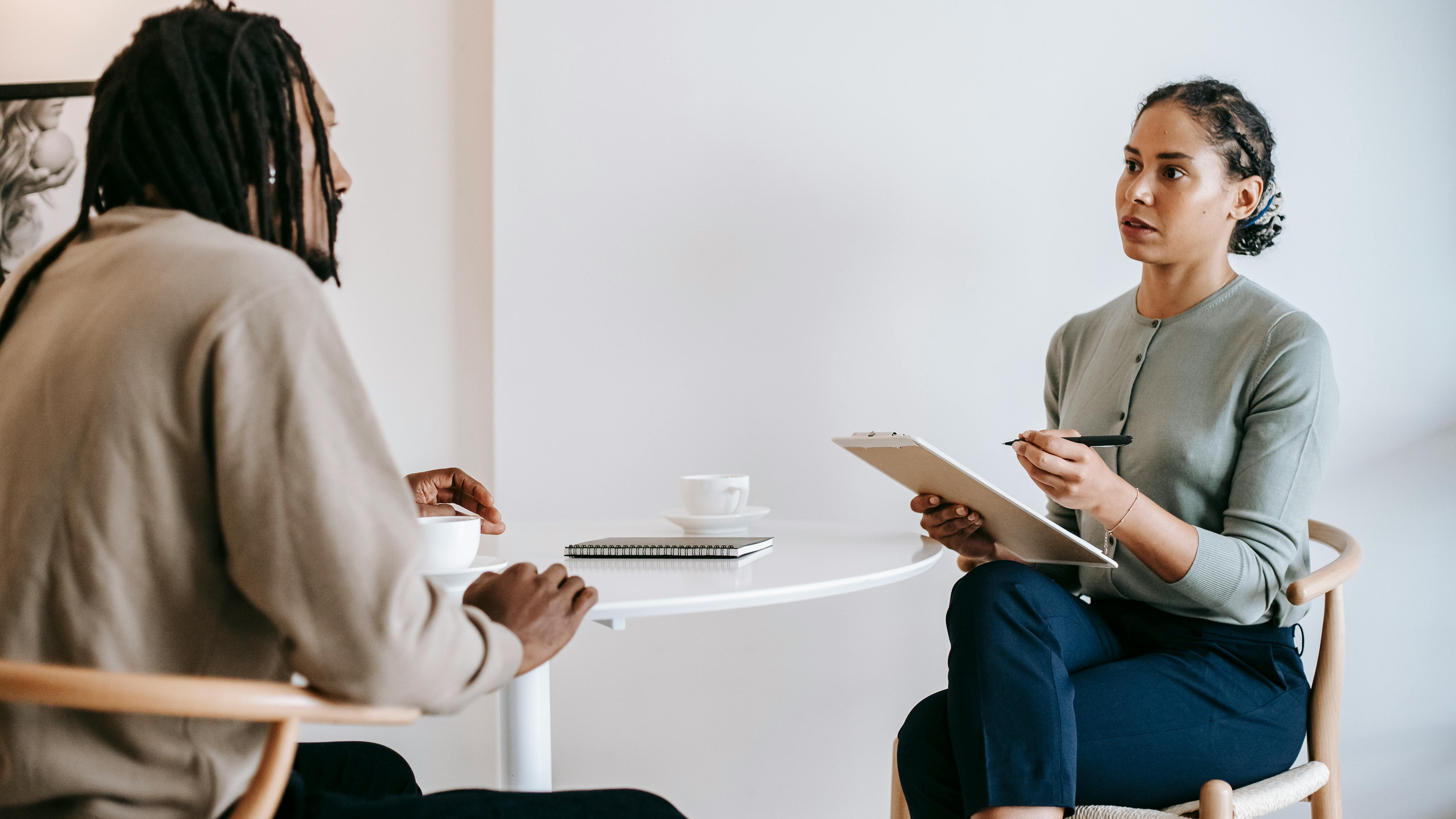 AI recruiting software: Humanoid robot and woman collaborating in office.