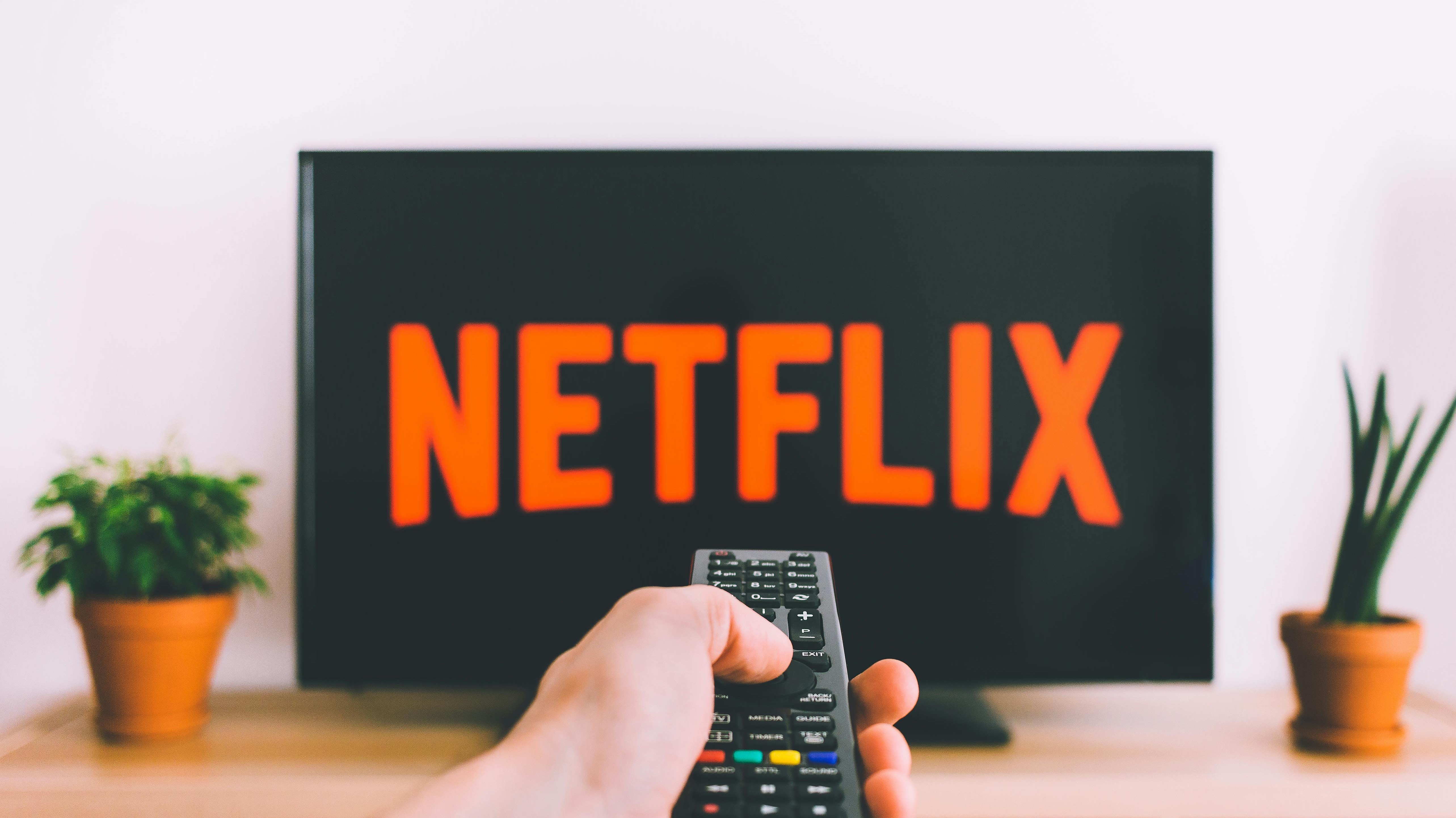 Netflix Error NW-2-4 on Samsung Smart TV being shown to a confused woman.