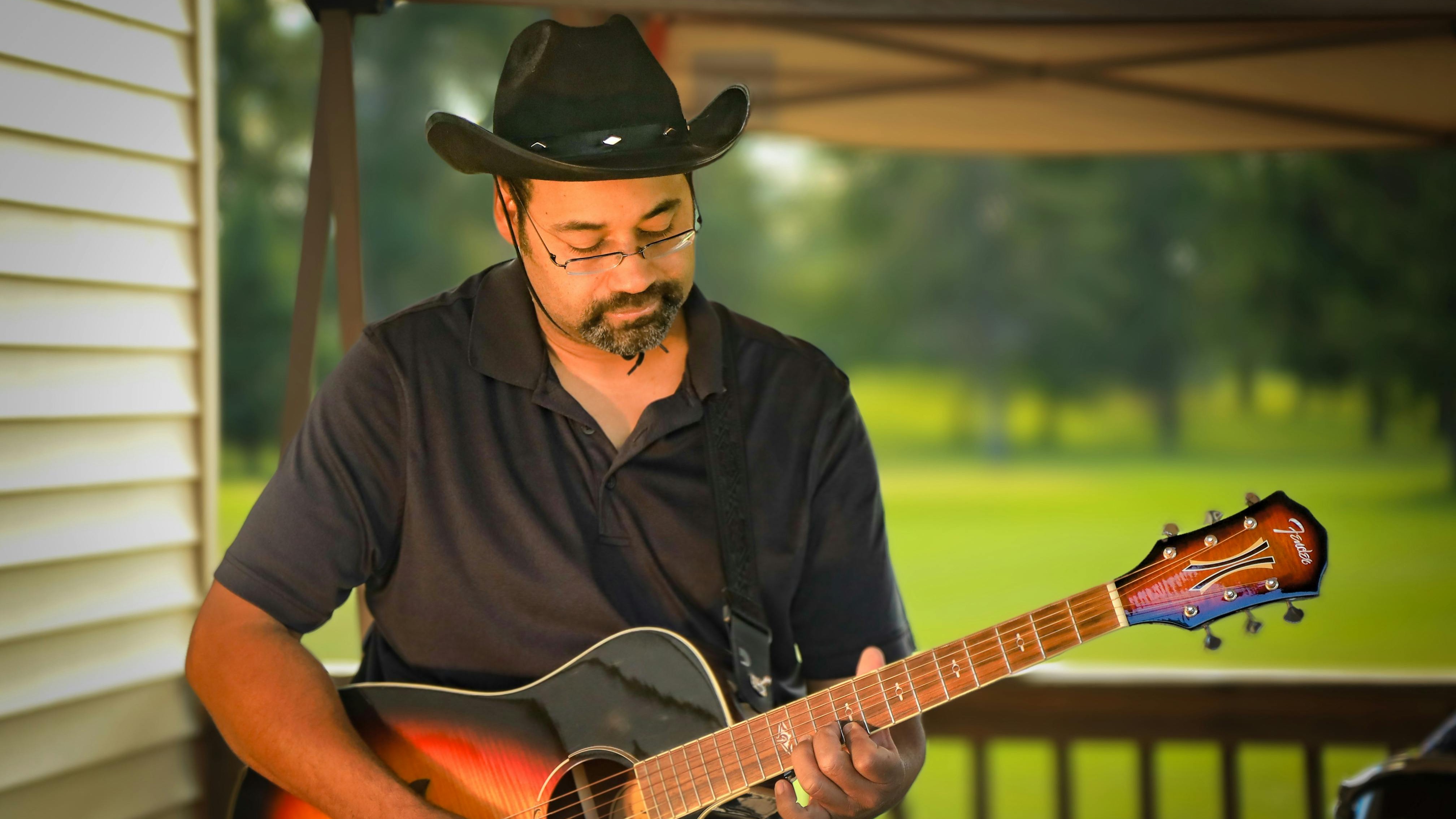 In the Market for Blues Festival Omaha performer with shades and hat.