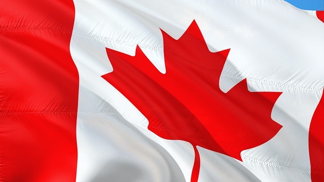 Canada AI Ethics Minister walking with Canadian flags in a grand hallway.