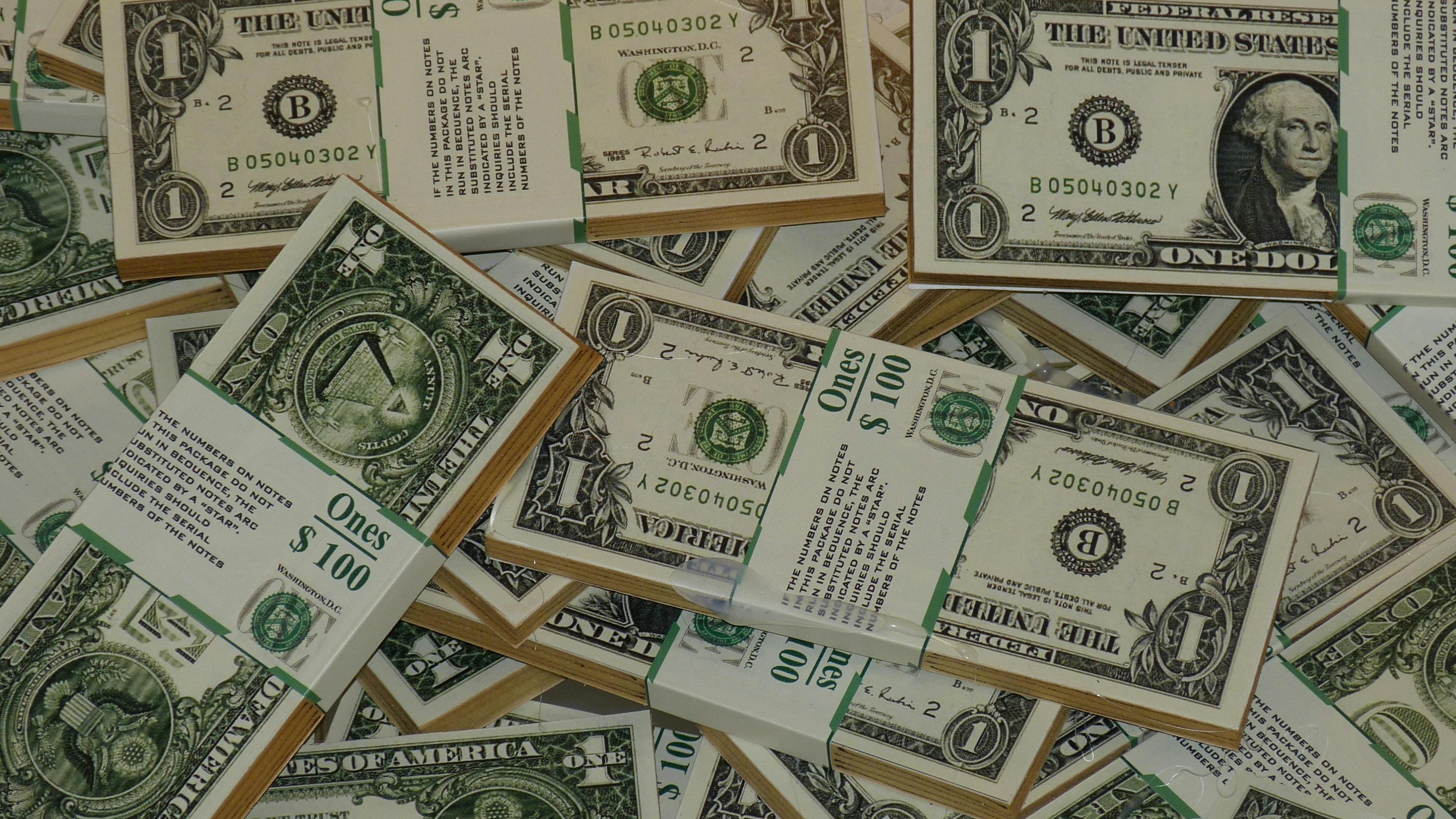 Stacks of blue-tinted hundred dollar bills; not spending is trending.