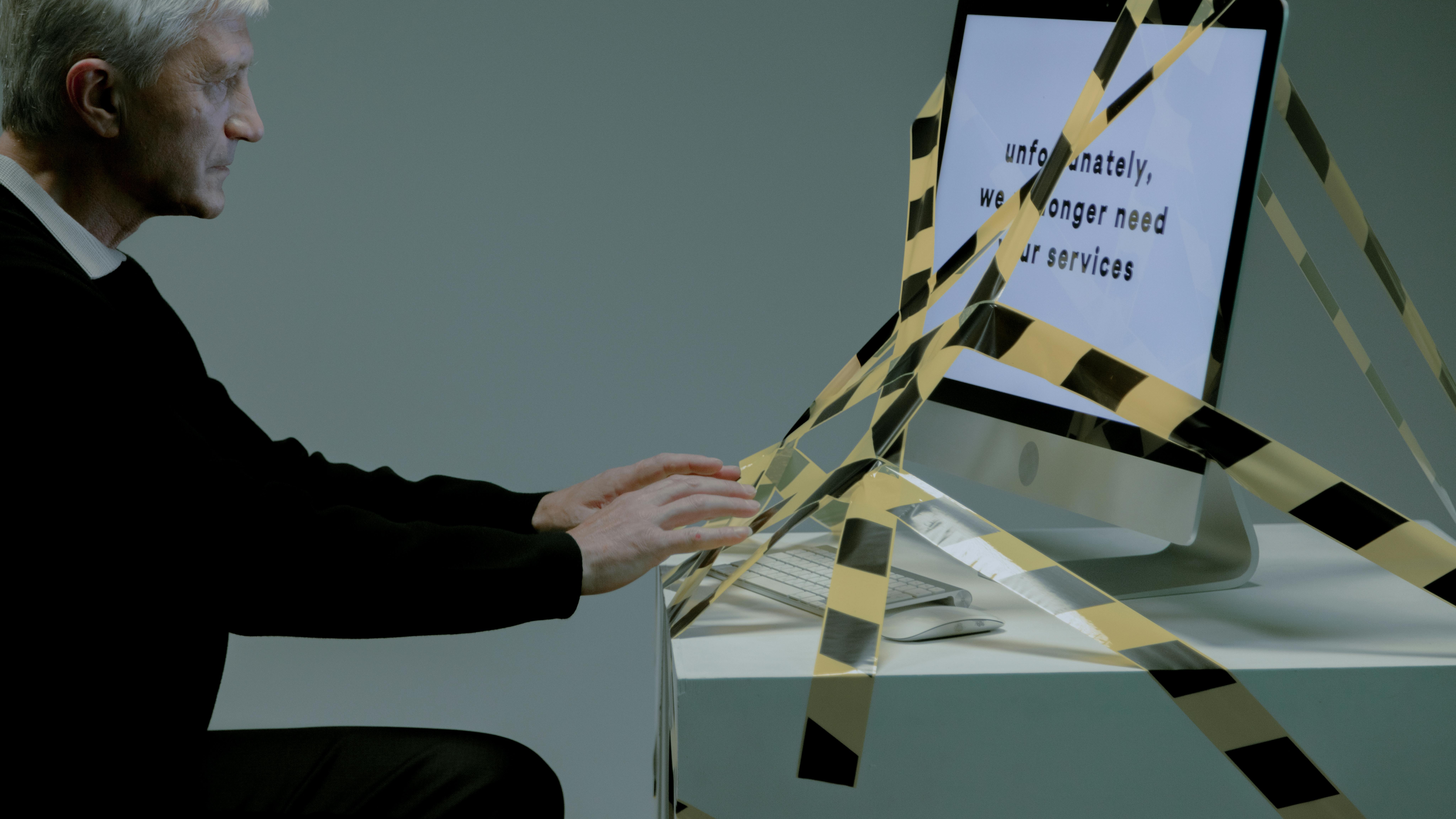 Employee leaving office with belongings in a box, teal background.
