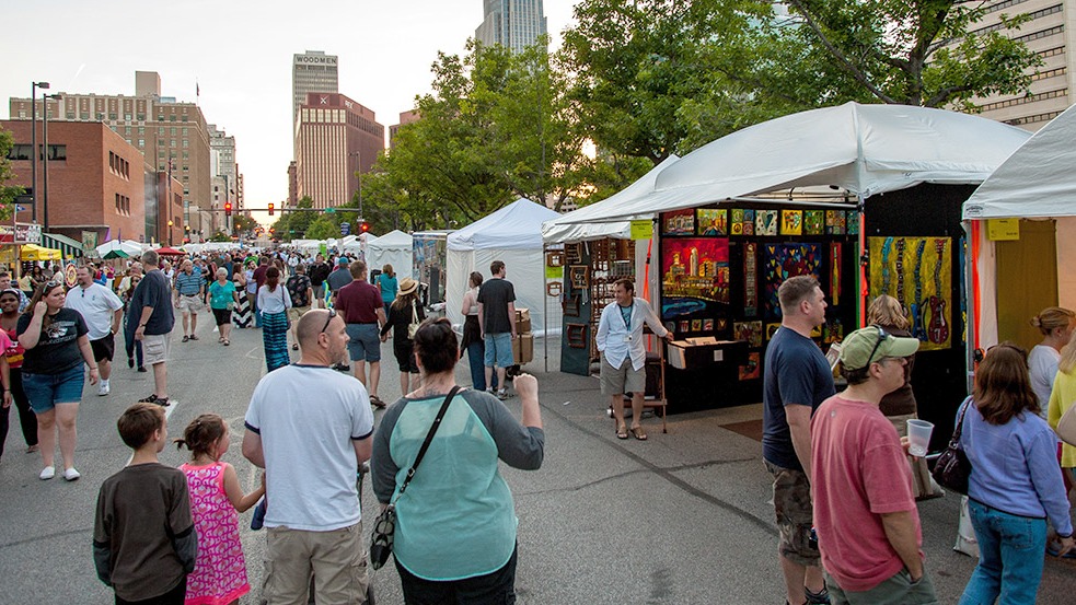 Outdoor banner for Omaha Art Fair engaging Omaha families with local artists.