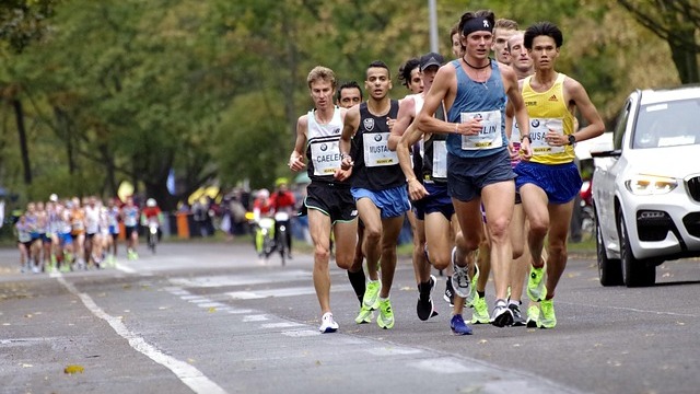 Energetic San Antonio Marathon runners racing through urban streets.