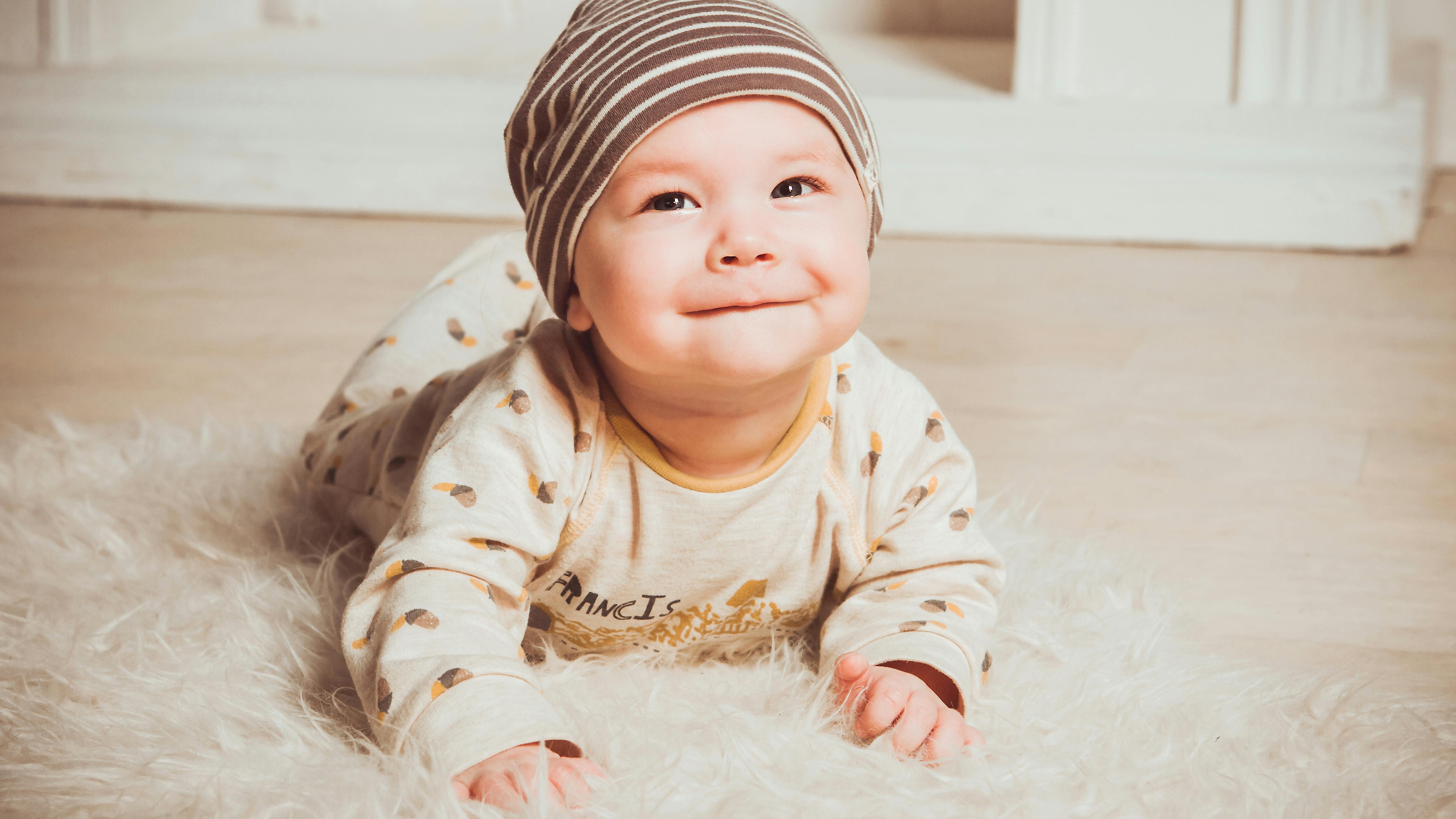 Adorable infant during tummy time, focused on a toy.